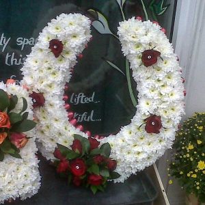 Horseshoe tribute of white flowers and dark red roses